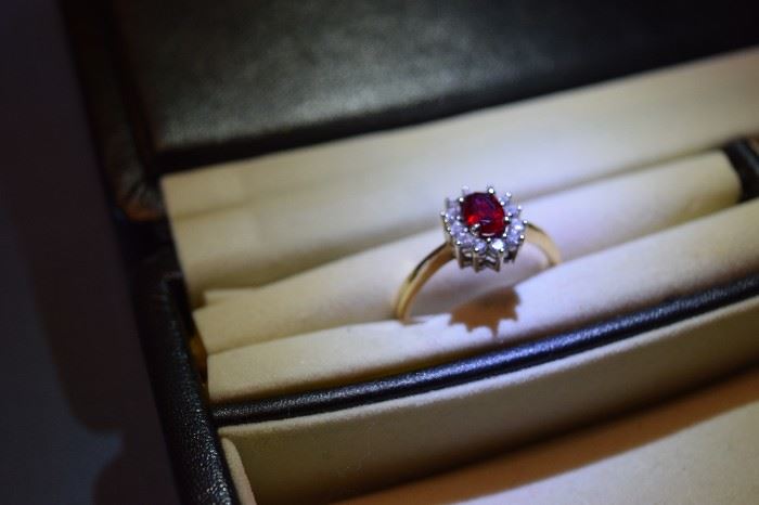 Ladies 14k yellow gold oval Ruby and diamond ring. The center Ruby is 7 X 5 mm approximate carat weight is 1.0 and AAA quality. The center stone is enriched with twelve round diamonds S11 clarity  and H-1 color. Total diamond weight is approximately .36 carats.