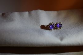 Pair of amethyst and diamond earrings in 14k gold. Each earring is set with a 7 X 5 mm oval amethyst A quality encircled by 14 round melle diamonds.