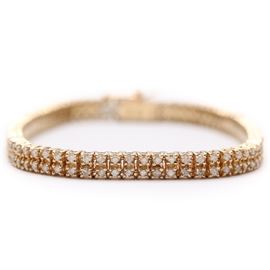 14K Yellow Gold 2.05 CTW Diamond Bracelet: A 14K yellow gold encrusted with diamonds. This features a thin boxed bracelet with two rows of embedded 2.05 ctw diamonds with a hidden box tab and a safety catch.
