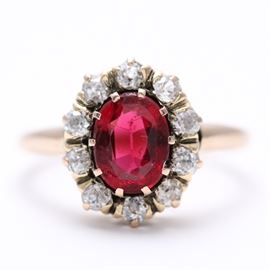 10K Yellow Gold Garnet and Diamond Ring: A 10K yellow gold garnet and glass doublet and diamond ring. This item features a smooth shank that leads to a crown of a prong set garnet and glass doublet surrounded by a halo of diamonds.