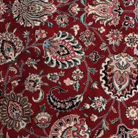 Hand-Knotted Bijar Area Rug: A hand-knotted Bijar area rug. This area rug features arabesque designs throughout the center on a deep red backdrop. A scrolling Herati pattern makes up the border on a black ground color. Cream colored, cotton fringe appear at either end of the rug. There are no maker’s marks or labels present.