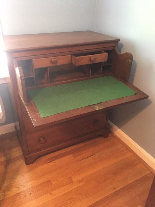 Unique antique writing desk with felted surface. Closes to give the appearance of a standard chest of drawers