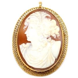 10K Yellow Gold Carved Shell Cameo Brooch Pendant: A 10K yellow gold carved shell cameo brooch pendant. The brooch features a female in profile with curled tendrils and classic style dress, being bezel set in a wire filigree mount. There is a worn illegible signature to brooch back.