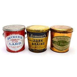 Three Vintage Tins Including Brains and Lard: A collection of three vintage tins. This unique selection features a five-pound, yellow and blue tin that once held Armour’s Pork Brains, a second five-pound tin, in brass tone with a green and white label that contained Swift’s Calf Brains, and a handled four-pound tin of Decker’s Piquality Pure Lard, in red, white, and blue.