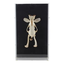 Bone Sculpture by Jan Knoop: A bone sculpture in a lucite acrylic shadowbox, by Jan Knoop, Cincinnati, OH. Titled Devil One, the horned, winged figure with forked tail is composed of possum, sheep, dog (?), and snapping turtle claws. Has gallery label and hanging wire to verso.
