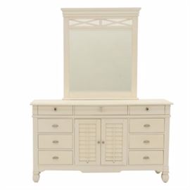 White Chest of Drawers With Mirror: An American Signature chest of drawers with detachable mirror. In a Pottery Barn-style with a matte white finish, the chest accommodates three short drawers over six drawers with center louvered cabinet door opening to three concealed drawers. Raised on shaped feet, having colorful porcelain pulls to top over cast aluminum pulls to lower drawers. Solid wood construction with dovetail joinery throughout.
