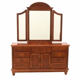Colonial Styled Dresser with Mirror: A Colonial style, cherry finished dresser with attached hinged mirror, by Wynwood / Flexsteel, having geometric marquetry inlay. The rectangular top is above nine drawers with wooden knobs and a centered cabinet, concealing two interior drawers, between reeded stiles, over turned feet. See 17CIN168-176 through 178, for companion items.