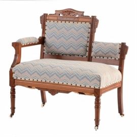 Walnut Eastlake Single-Arm Settee: A walnut Victorian Eastlake settee, having a burled veneered and incised carved frame with one, right-hand arm (sitter’s), turned legs and porcelain casters. The piece in covered in a flamestitch fabric, in teal and peach.