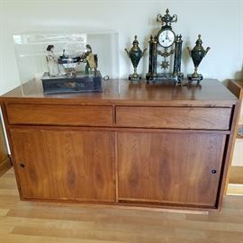 Dillingham Mid-Century walnut cabinet with sliding doors under two drawers.  On top:  Automaton music box, and French garniture clock set