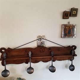Pewter spoons in carved rack