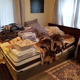 Electric adjustable bed displaying furs, linens, etc.