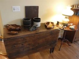 One of the mid-1800's tables. You can see the use marks soaked into the wood. It needs to stay in it's natural state. Standing up is the back side which is one straight piece of wood with indications where the hinge was