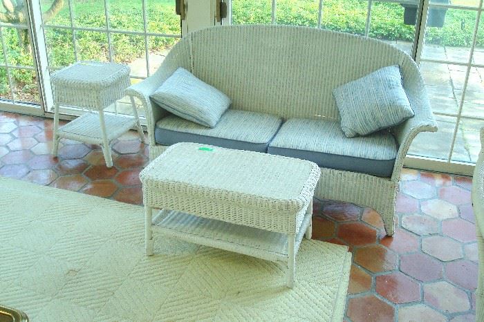Antique wicker coffee table, settee, and lamp stand.