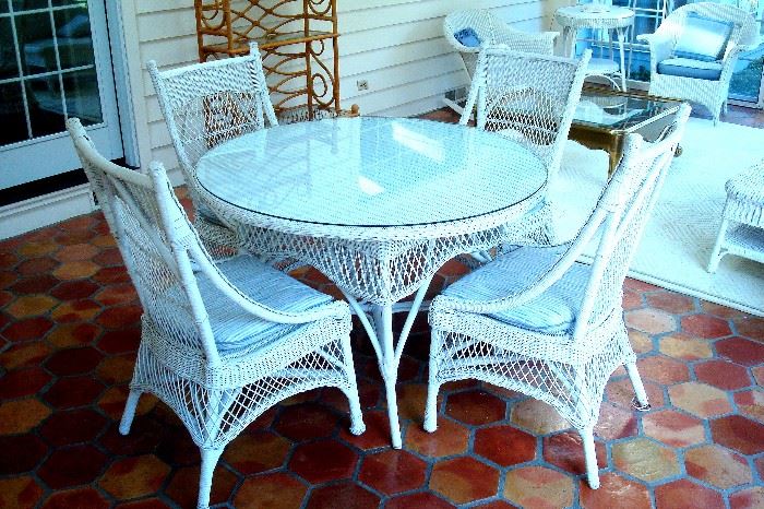 Wicker round table with glass top and four matching chairs.