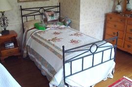 One of a pair of twin beds and bedding.