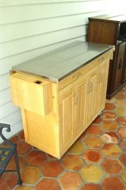 Maple drop leaf kitchen island with doors, drawers and metal top surface.