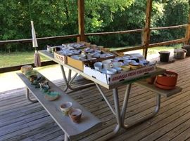 Picnic table (not for sale) but covered with coffee cups & flower pots
