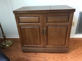 Sewing machine and cabinet.  Sewing machine raises with the touch of a button!