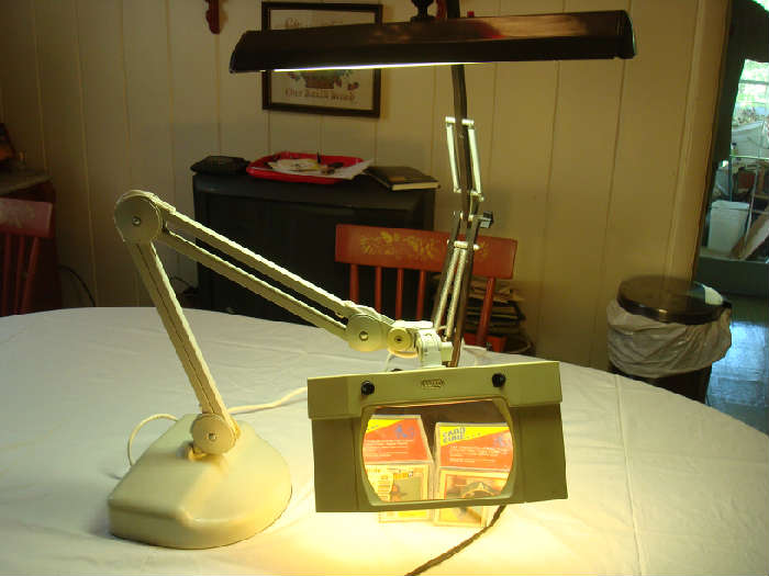 Two working desk lamps. The lamp in the foreground includes a powerful magnifying glass ideal for those working on/or repairing watches, tools toys, etc.