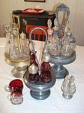 Condiments and salad dressing servers from the early 1900's - 1930's on brass and pewter stands. One glass server on the brass stand is cracked (not visible). Small glass in lower left sales "World's Fair 1904.