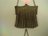 A close up of a beautiful metal beaded purse Circa the 1920's. We're testing it to determine whether the latch and frame are sterling silver. The craftsmanship is outstanding and the purse is in excellent condition. A little metal polish will bring this piece of history back to life.