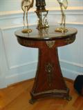 You could probably purchase an entire living room group at a one of the many bargain furniture stores for the what the original cost was on one of the lovely tables you have seen so far.
This one is no exception. Look closely at the metal work that surrounds the table. Study the beautifully curved table base and all its ornate trim right down to the triple claw feet at its base. This is no table for the masses. This is a table for someone with a sense of style couple with an appreciation for history and craftsmanship.