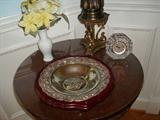 A close up of some of the exquisite accessories available in this multimillion dollar home. First, examine up close the quality of craftsmanship in the solid brass lamp as well as this silver dish embedded in its cherry wood base. look at the filigree work on the dish. It's lovely as is the small glass clock made in Germany.