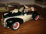 The Honeymooners original sculpture in glazed ceramic featuring string-tied tin cans to the read bumper and newlyweds driving the car. About 12" in by 6" by 5".