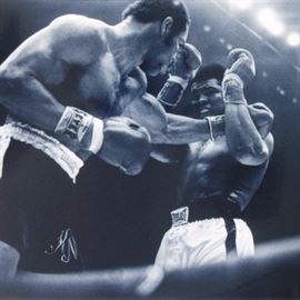 Muhammad Ali and Ken Norton Licensed Photograph: A licensed photograph on paper depicting boxers Muhammed Ali and Ken Norton mid-match. Presents unframed.