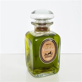 Hermès Caleche Parfum Bottle: A glass bottle of Caleche perfume by Hermès. The bottle is rectangular in shape and has a stopper. The original label is marked with the horse and carriage logo.