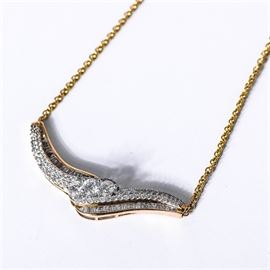 14K Yellow Gold and 2.91 CTW Diamond Bypass Pendant Necklace: A 14K yellow gold bypass design pendant accented by layers of round and baguette cut diamonds. The link chain attaches to the pendant on two sides and features a lobster clasp closure. The diamonds have a total approximate weight of 2.91 ctw.