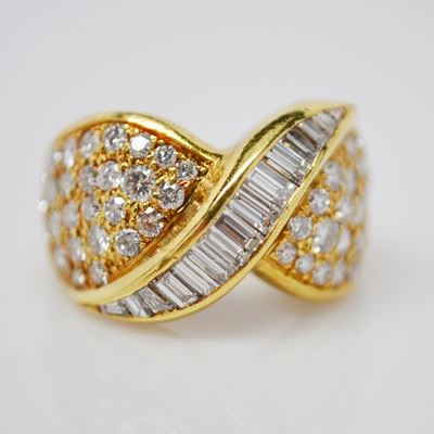 18K Yellow Gold 2.00 CTW Diamond Dome Style Ring: An 18K yellow gold 2.00 ctw diamond dome style ring. This ring features a twisted front design with channel-set baguette diamonds, and is embellished with yellow gold accented round brilliant cut diamonds.