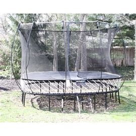 Springfree Trampoline: A square Springfree trampoline with Flexinet safety enclosure and FlexrHoop. Springfree trampolines are promoted by the manufacturer as “The world’s safest trampolines.” Instead of springs, this model has composite rods positioned below the jumping surface, and out of harm’s way. The total space required to set up is 19 × 19′. Unit stands slightly 9’ above ground when set up. Will need to be disassembled to remove as the supports are buried.