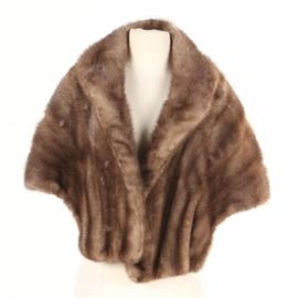 Mink Fur Stole: A mink fur stole. This classically cut fur stole features a shawl collar with tawny hued mink. The piece is finished with a tonal taupe lining and embroidered monogram of “OWM”.