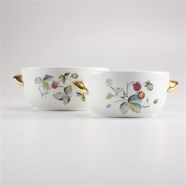 Two Royal Worcester Porcelain Bowls: A pair of Royal Worchester porcelain bowls. Each white fireproof porcelain bowl has gold-tone handles and displays a foliate pattern with strawberries. Each piece is marked to the underside “Royal Worcester Made in England Fireproof Shape 23 Size = 5”.