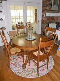 Antique round oak table with 2 leaves and claw feet          4 antique oak pressed back chairs--3 of which are newly hand caned                                                                    Beautiful pink hand hooked rug