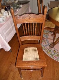 One of 4 antique hand caned pressed back oak chairs