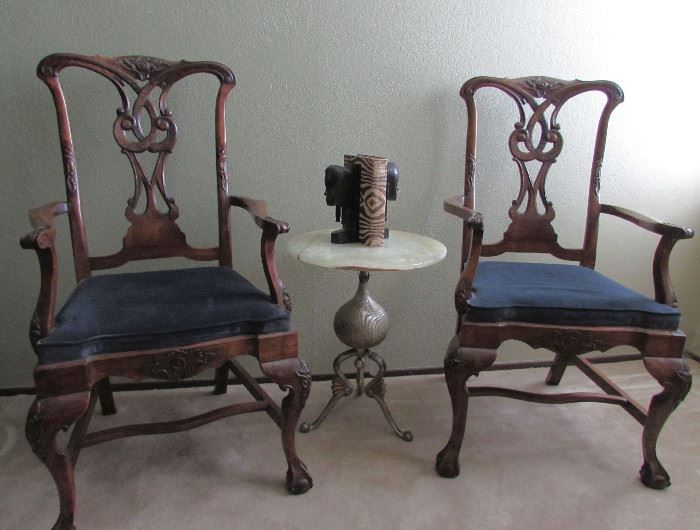 Chippendale Host and Hostess Arm Chairs - Ball and Claw Feet, Hand Carved  Backs, Arms and Legs.  One of two Luna Bella marble topped tables. African bookends on table