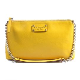 Kate Spade Byrd Wellesley Leather Shoulder Bag: A Kate Spade Byrd Wellesley leather shoulder bag. This small leather handbag in yellow features a chain and leather strap, gold-toned hardware, and a zip closure. The interior is lined in a polka dot fabric and has three pockets. Serial number Q064.