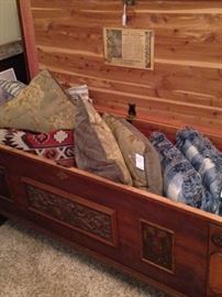 Cedar chest full of some of the many decorative pillows
