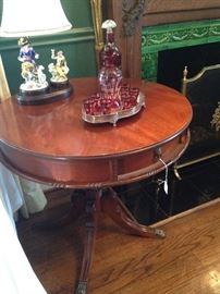 Antique drum table; figurine lamp; red decanter set