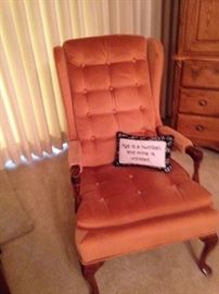 Orange arm chair; pillow: "Age is a number, and mine is unlisted."