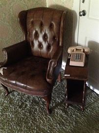 Brown leather wingback chair and small side table