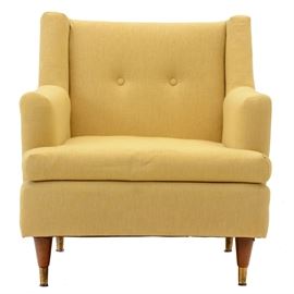 Vintage Yellow Armchair: A vintage armchair upholstered in yellow fabric. It has two buttons on the back, a removable seat cushion, and rounded, tapering hardwood feet with brass caps. Unmarked.