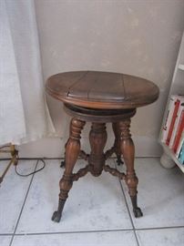 Antique Piano Stool - has claw feet with clear rollers.