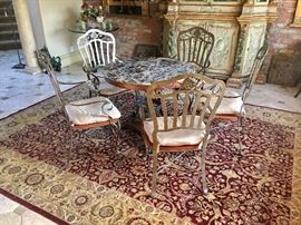 Persian rug, round rams head paw footed marble top table, heavy pewter finish metal chairs 