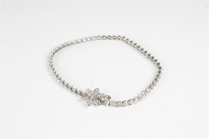 10K White Gold Diamond Flower Bracelet: A 10K white gold 1.00 ctw diamond bracelet with a flower clasp.