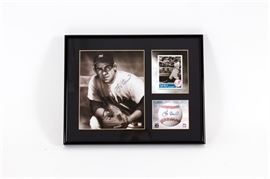 Yogi Berra Signed New York Yankees Lithograph: A Yogi Berra signed New York Yankees lithograph. It features an official MLB hologram-stamped image of Berra that has been hand signed by the player, an image of his baseball card, and an image of a baseball with a facsimile signature. All three are set in a black, partitioned matting and protected by a clear plastic sleeve. This piece is numbered 144/5000 and includes a Toon Art Inc. certificate of authenticity.