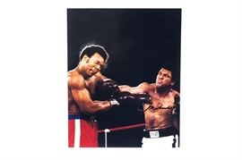 Muhammad Ali Signed Boxing Photograph: A Muhammad Ali signed boxing photograph. It depicts Ali delivering a powerful punch to Larry Holmes. Signed to the boxer’s chest. Comes in a protective plastic sleeve with an authentication letter from Les Wolff of Sports LLC.