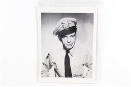 Don Knotts Signed "The Andy Griffith Show" Barney Fife Photograph: A Don Knotts signed Barney Fife lithograph. The black and white image depicts the beloved Andy Griffith Show Sheriff’s deputy staring at the viewer with the look of determination on his face. Signed “Don Knotts” to the bottom right side, and numbered 887/1000 to the bottom left. The piece is protected by a plastic sleeve and comes with both a Hometown TV, Inc. letter of authenticity and a contemporary image of Knotts on the reverse.